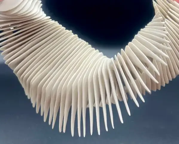 Fehér bordázott porcelán nyaklánc részlet kék háttéren